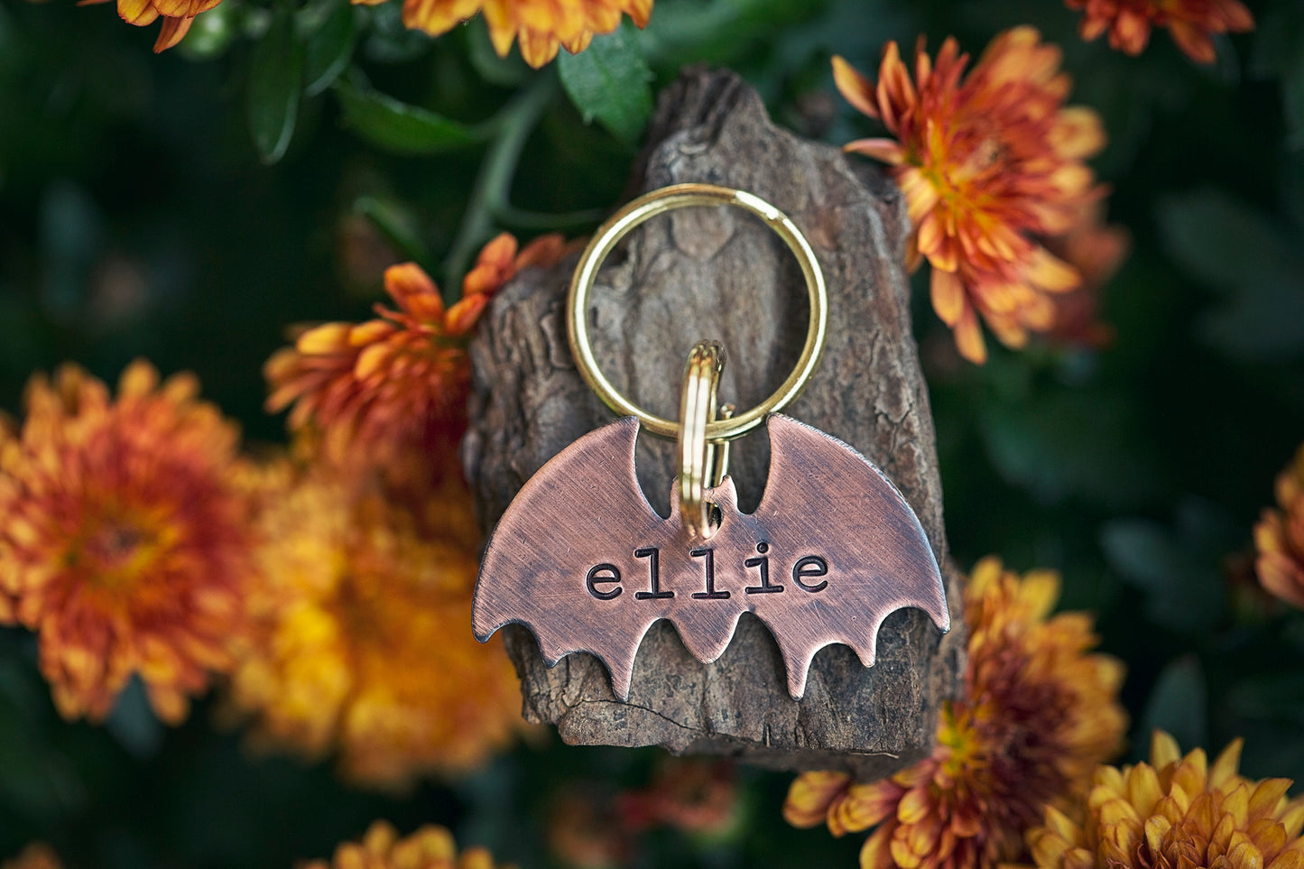 This is a bat-shaped dog or cat ID tag. It is made of copper and hand-stamped with your pet's name on the front and an optional phone number on the back.
