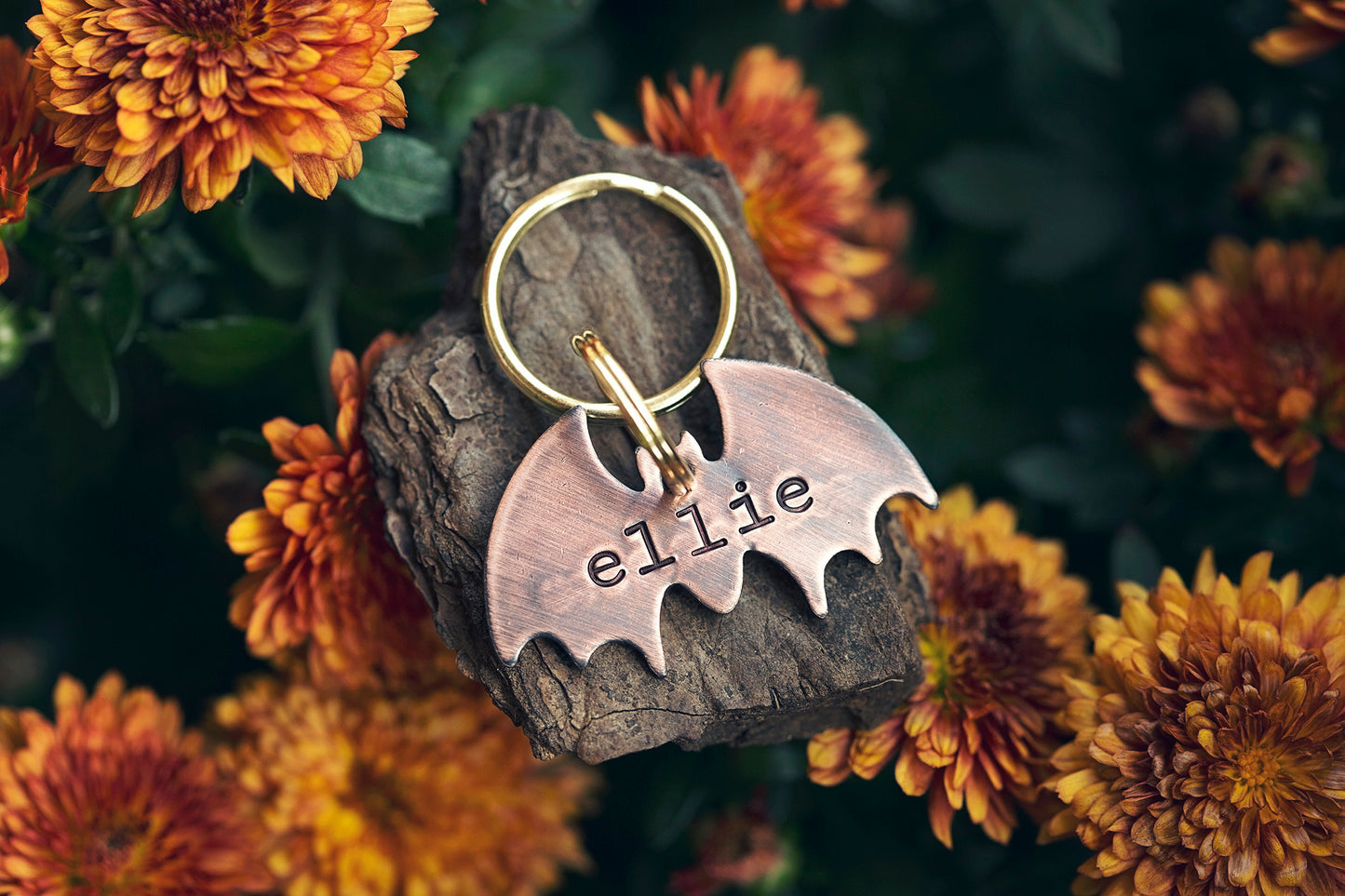 This is a bat-shaped dog or cat ID tag. It is made of copper and hand-stamped with your pet's name on the front and an optional phone number on the back.