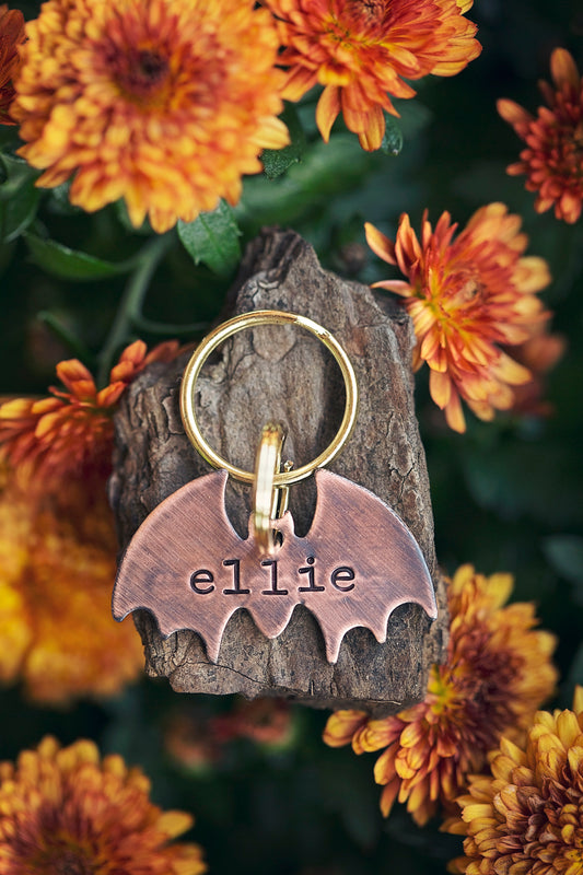 This is a bat-shaped dog or cat ID tag.  It is made of copper and hand-stamped with your pet's name on the front and an optional phone number on the back.